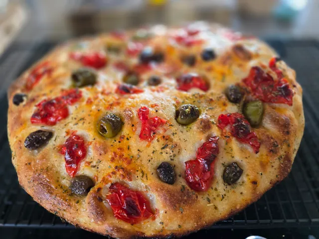 Goldbraune Focaccia mit Tomaten und Oliven auf Kühlgitter