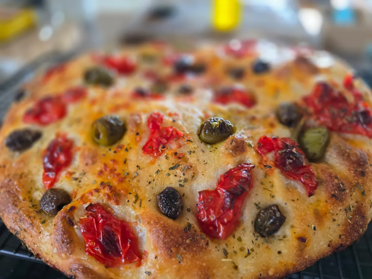Focaccia Nahaufnahme — goldbraune Kruste mit eingebackenen Tomaten