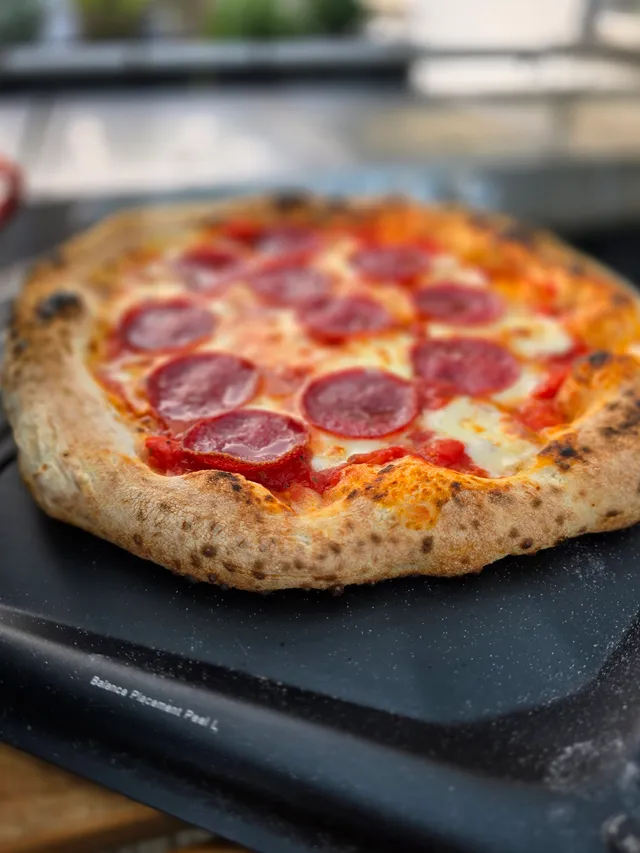 Frisch gebackene neapolitanische Salami-Pizza auf Gozney-Schaufel mit perfektem Cornicione