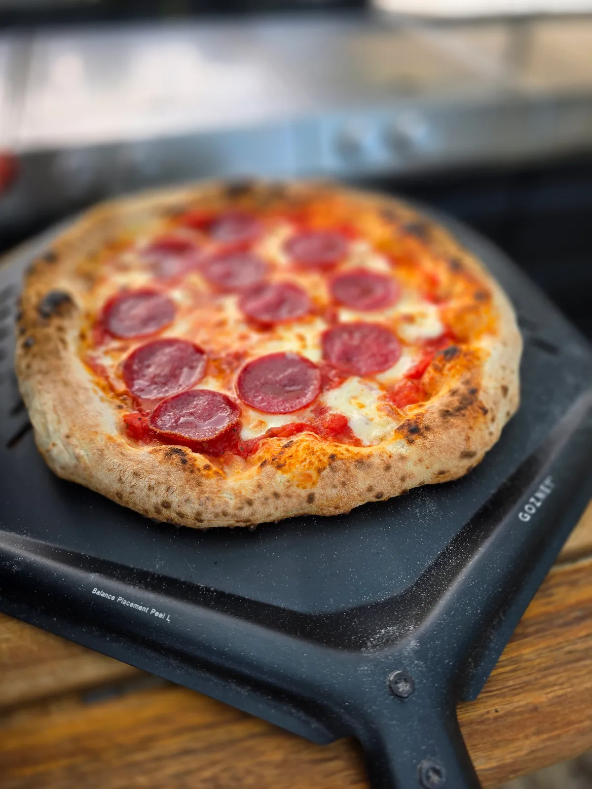 Fertig gebackene neapolitanische Pizza auf der Gozney-Schaufel — perfekter Cornicione mit Leoparding