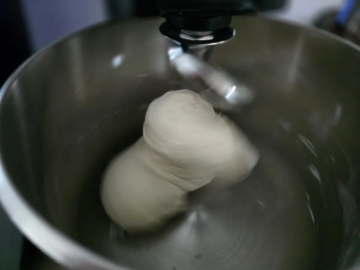 Pizzateig in der Küchenmaschine — Teig am Knethaken während des Knetvorgangs