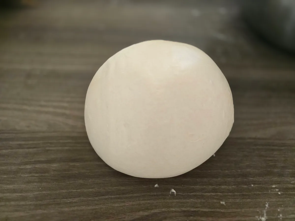 Perfekt geformter Pizzateig-Ballen nach der Mozzatura